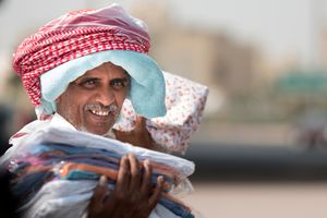 Friendly street vendor in Al Jahra, Kuwait, showcasing traditional wear.