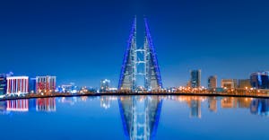 Stunning night view of Bahrain World Trade Center with clear water reflections and modern skyline.